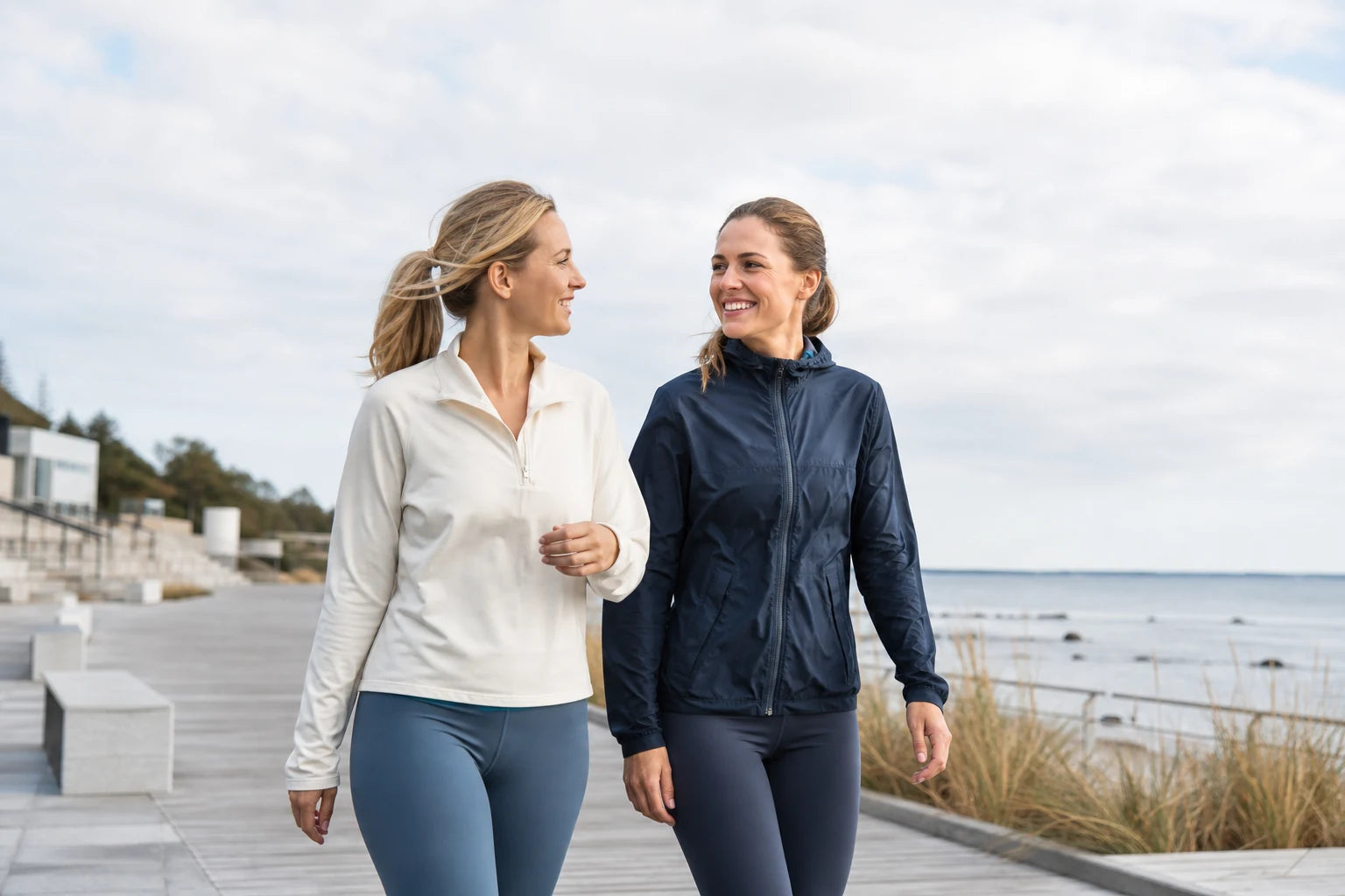Two women walking together beside the Baltic Sea